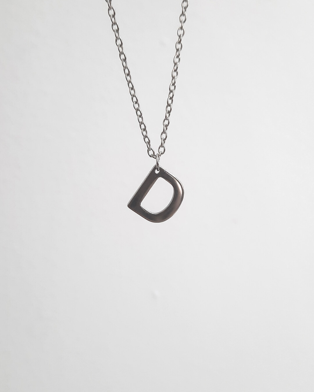 Colgante con forma de letra d de acero inoxidable