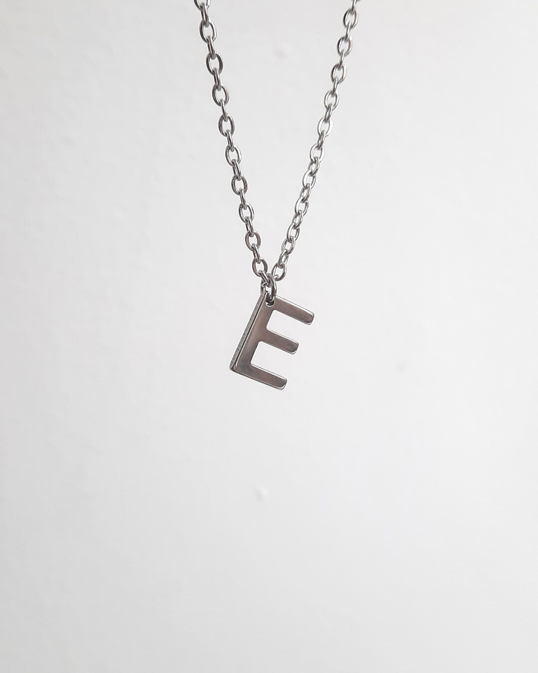 Colgante con forma de letra e de acero inoxidable