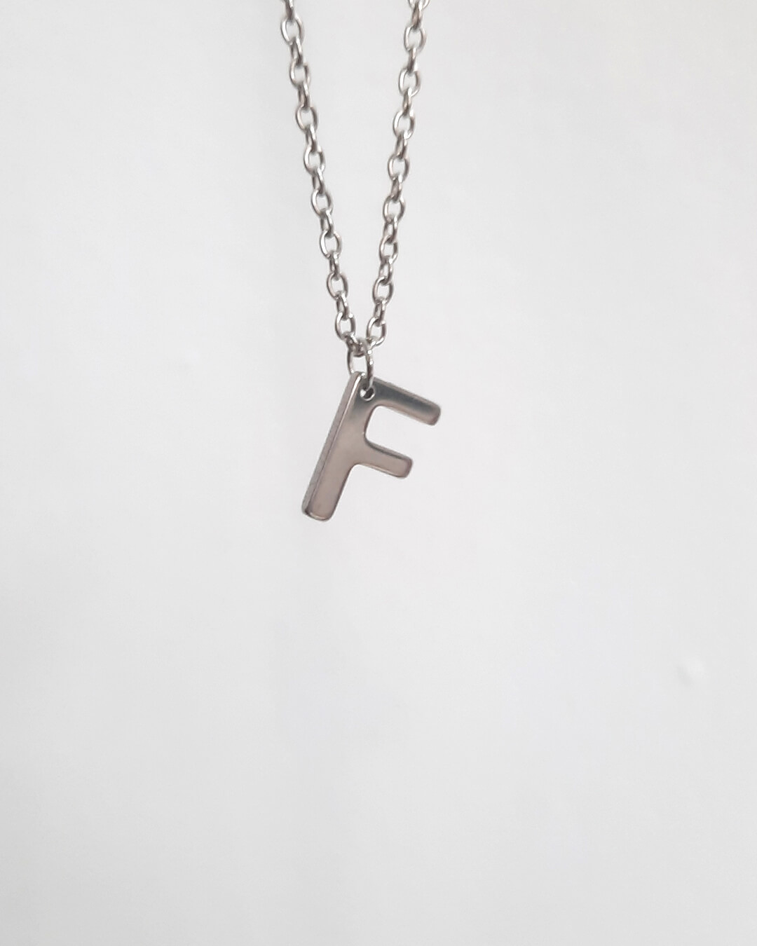 Colgante con forma de letra f de acero inoxidable