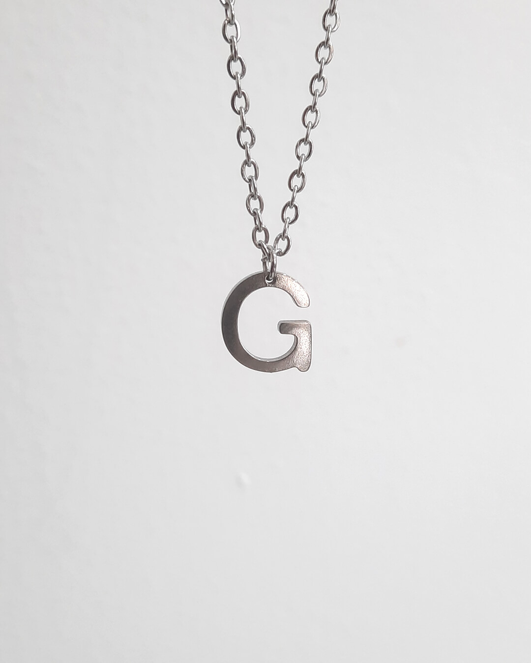 Colgante con forma de letra g de acero inoxidable