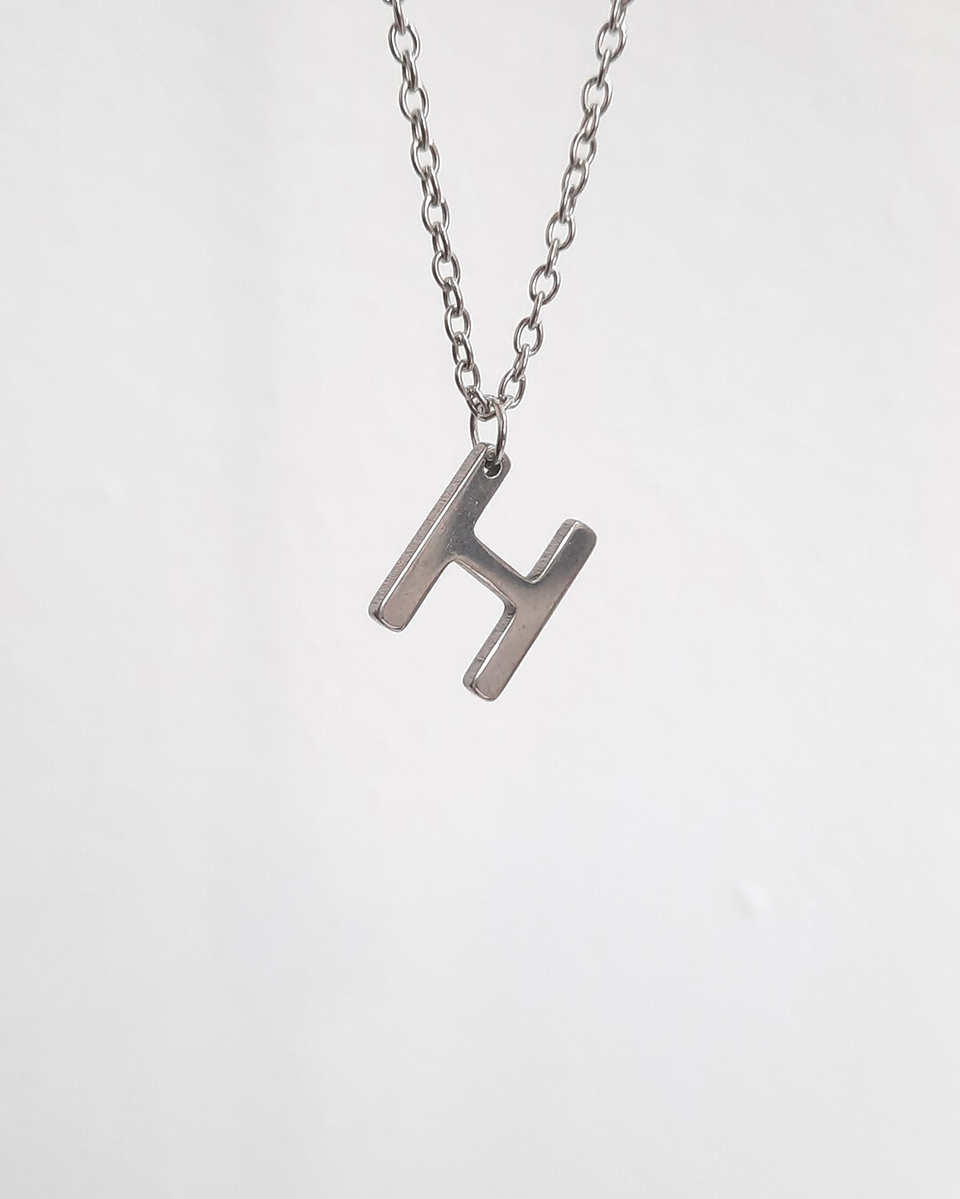 Colgante con forma de letra h de acero inoxidable