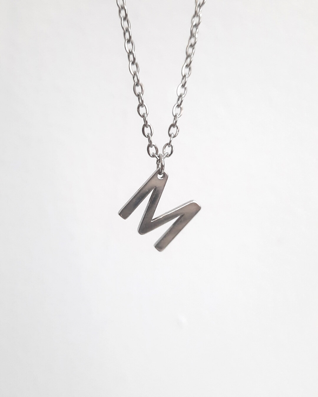 Colgante con forma de letra m de acero inoxidable