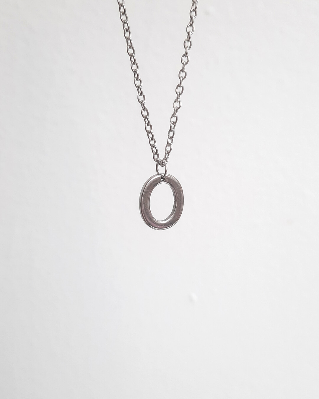 Colgante con forma de letra o de acero inoxidable