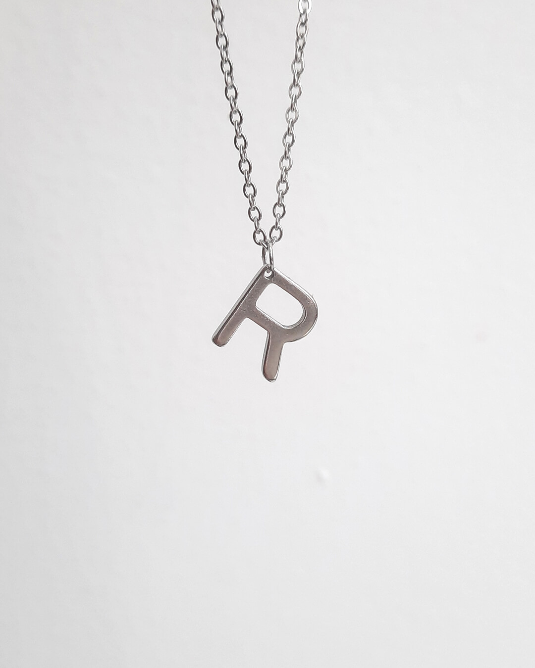 Colgante con forma de letra r de acero inoxidable