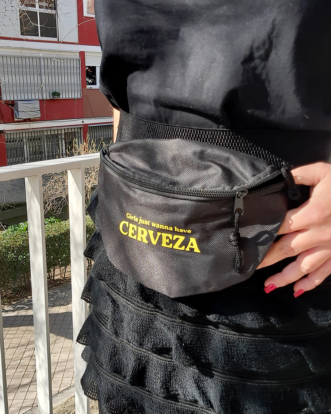 Riñonera negra con la frase Girls just wanna have fun en color amarillo