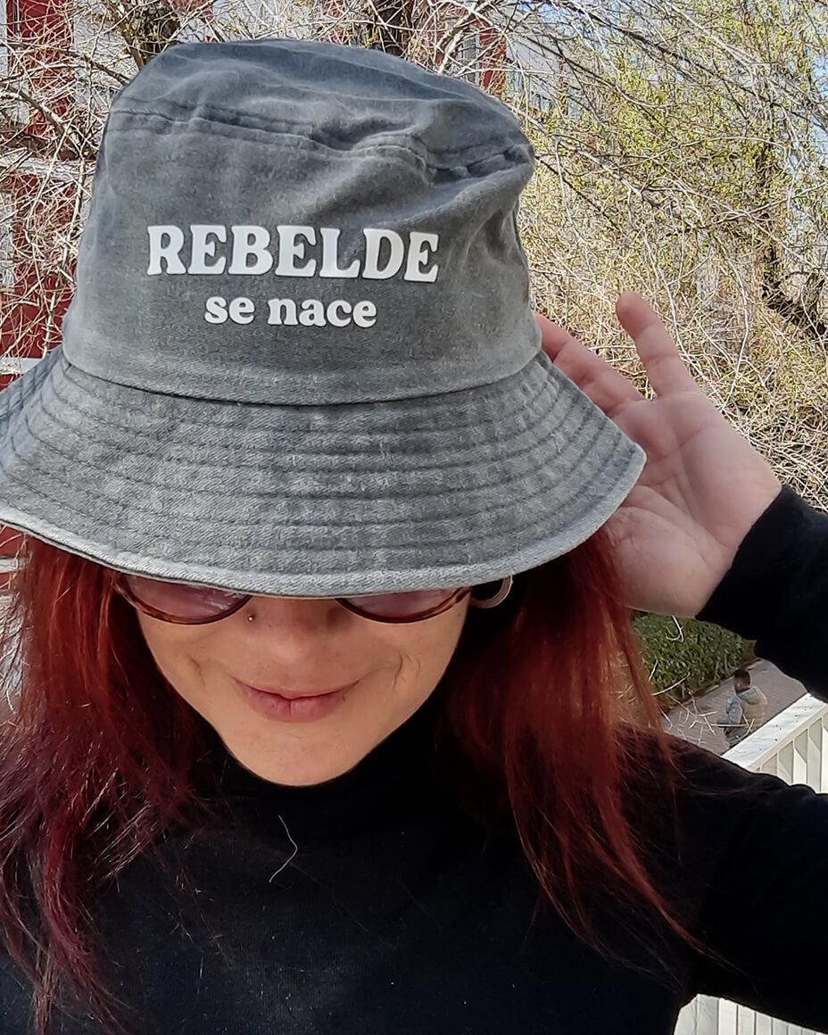 Gorro gris con la frase Rebelde se nace estampada en color blanco
